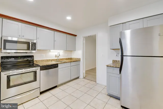 a kitchen with granite countertop cabinets and steel stainless steel appliances with cabinets
