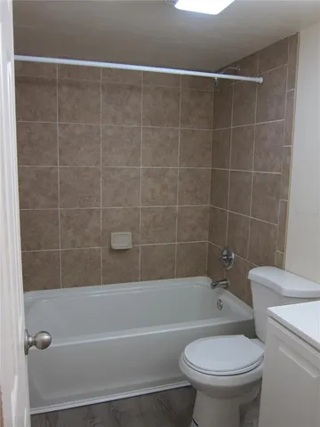 a white toilet sitting next to a bath tub