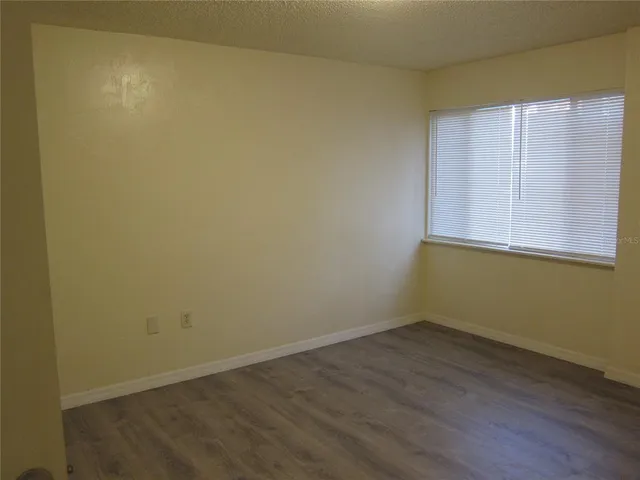 an empty room with wooden floor and closet