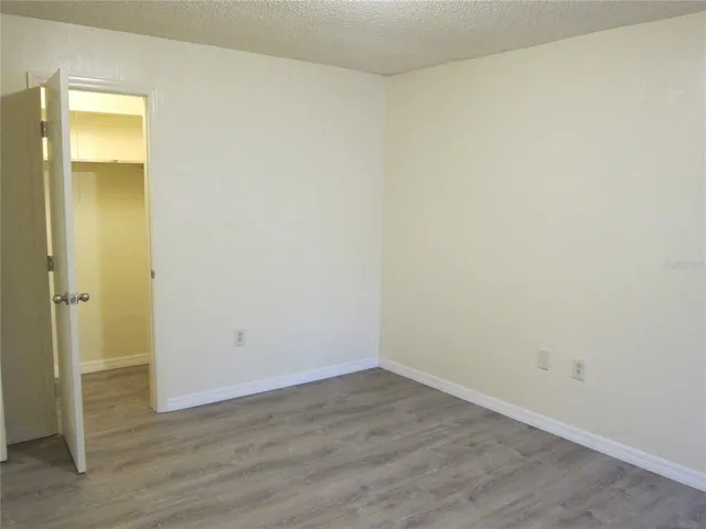 an empty room with wooden floor and closet
