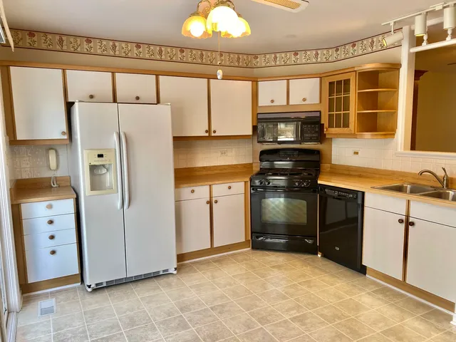 a kitchen with stainless steel appliances granite countertop a refrigerator and a stove