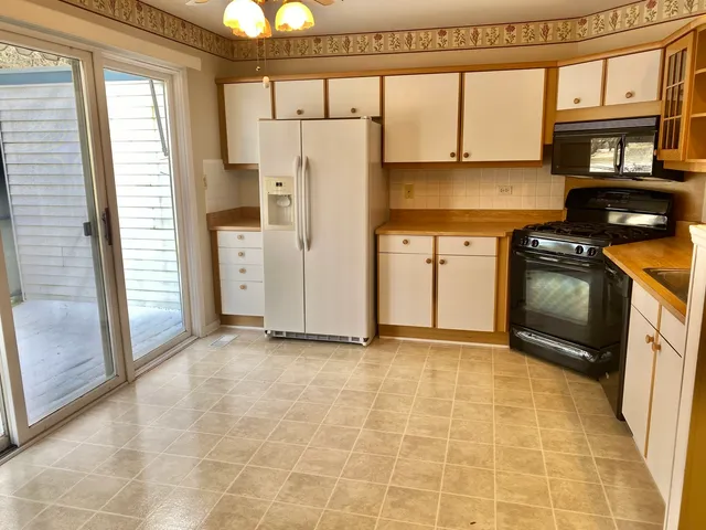 a view of a kitchen with a refrigerator a sink and a window