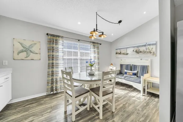 a kitchen with stainless steel appliances kitchen island granite countertop a table chairs and a refrigerator