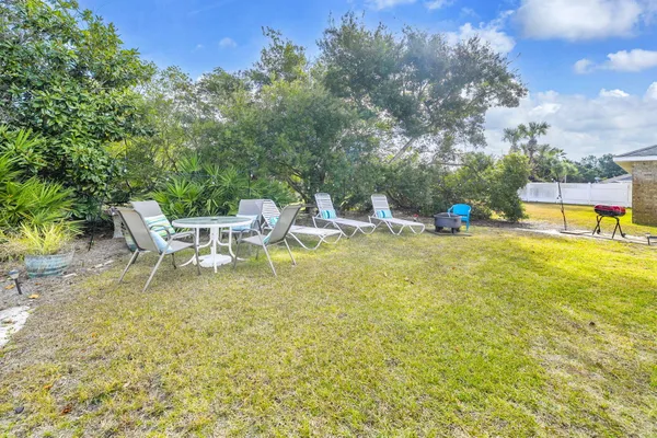 a view of a backyard with table and chairs and a barbeque