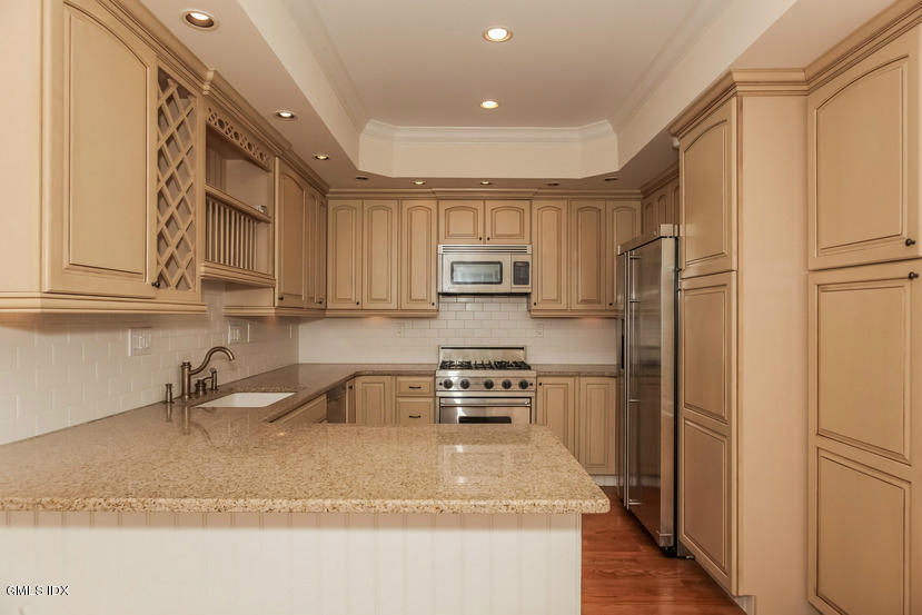 25 Decatur Street, Unit A Cos Cob, CT 06807 - Photo 11 of 29 a kitchen with stainless steel appliances granite countertop a refrigerator sink and cabinets