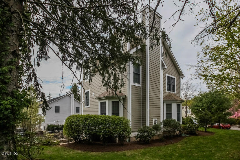 25 Decatur Street, Unit A Cos Cob, CT 06807 - Photo 29 of 29 a front view of a house with a yard and trees
