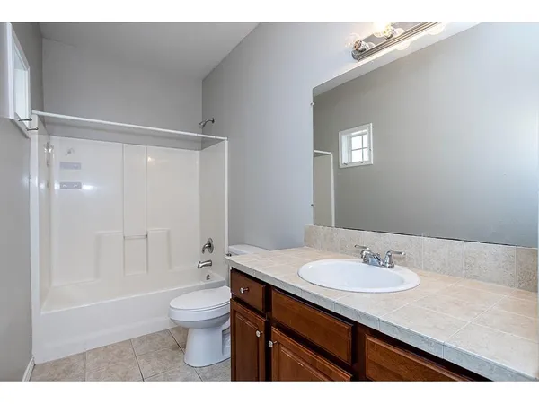 a bathroom with a sink a toilet a shower and a mirror