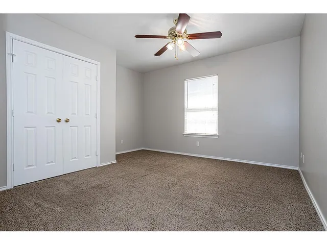 a view of empty room with ceiling fan