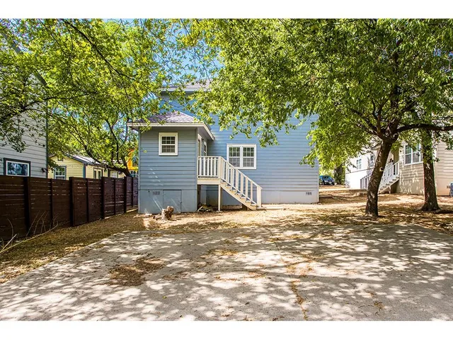 a backyard of a house with a large tree
