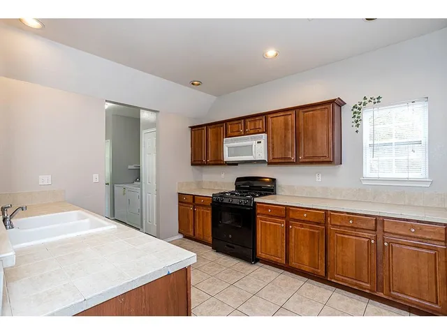 a kitchen with stainless steel appliances granite countertop a sink dishwasher stove and microwave
