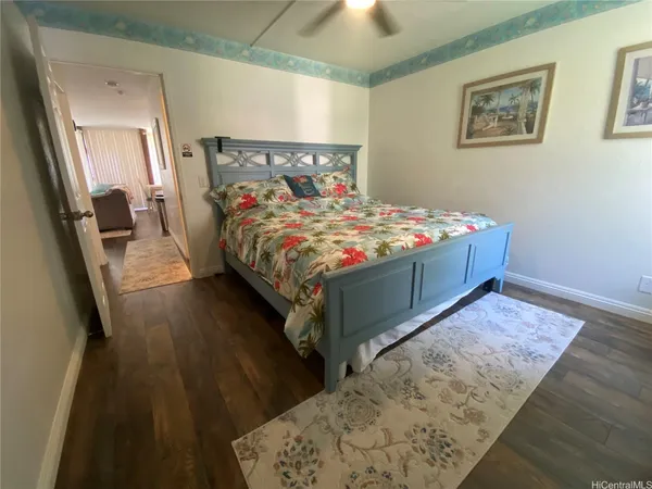 a bedroom with a large bed and a wooden floor