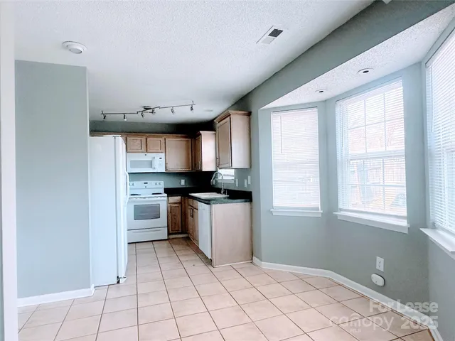 a kitchen with a refrigerator and windows