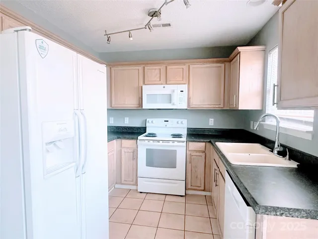 a kitchen with a refrigerator sink and cabinets
