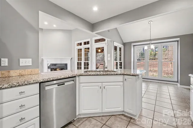 a open kitchen with granite countertop white cabinets and white appliances