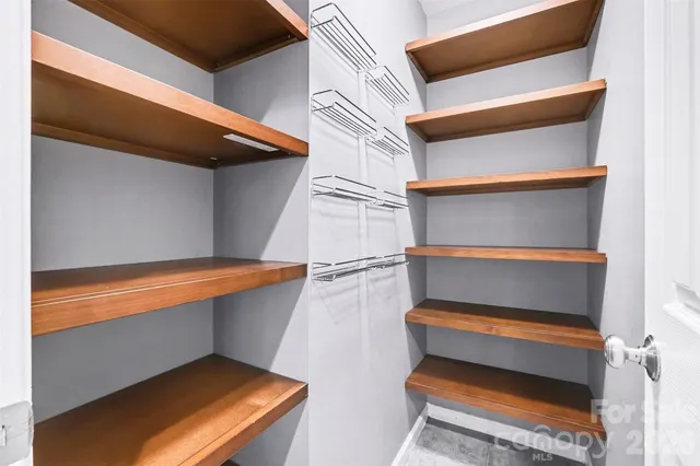 a view of walk in closet with empty racks