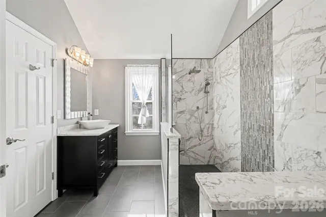 a bathroom with a granite countertop sink mirror and a bathtub