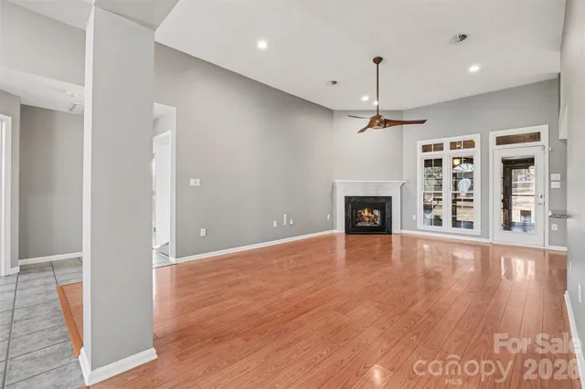 an empty room with wooden floor and fireplace