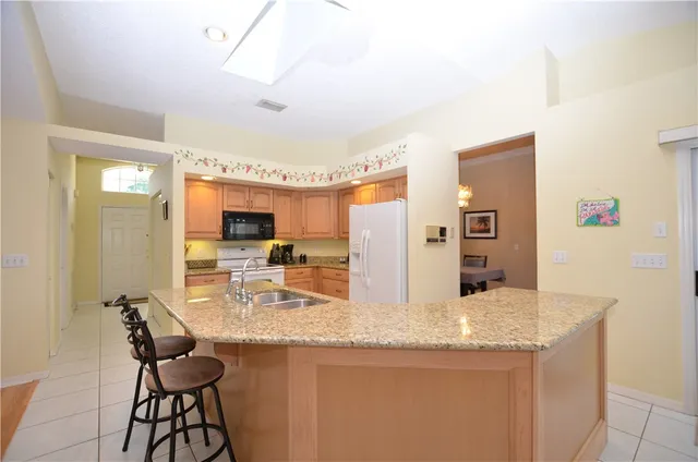 a kitchen with granite countertop sink and refrigerator