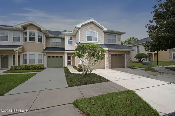 a front view of a house with a yard and garage