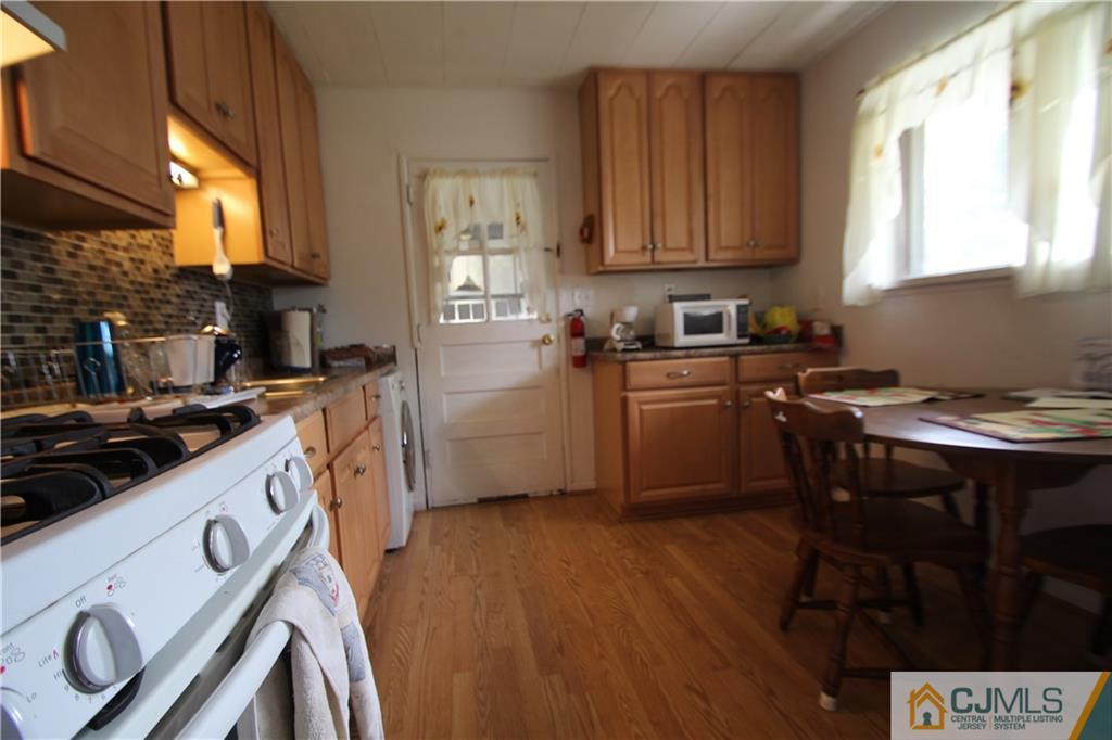 3 Vernon Road Edison, NJ 08817 - Photo 7 of 16 a kitchen with a stove a sink wooden floor and a window