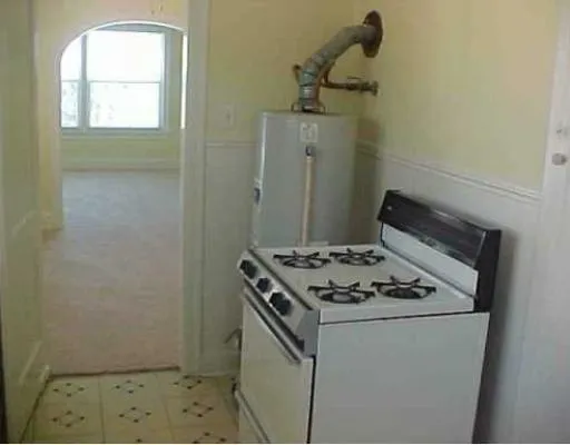 a stove top oven sitting inside of a kitchen