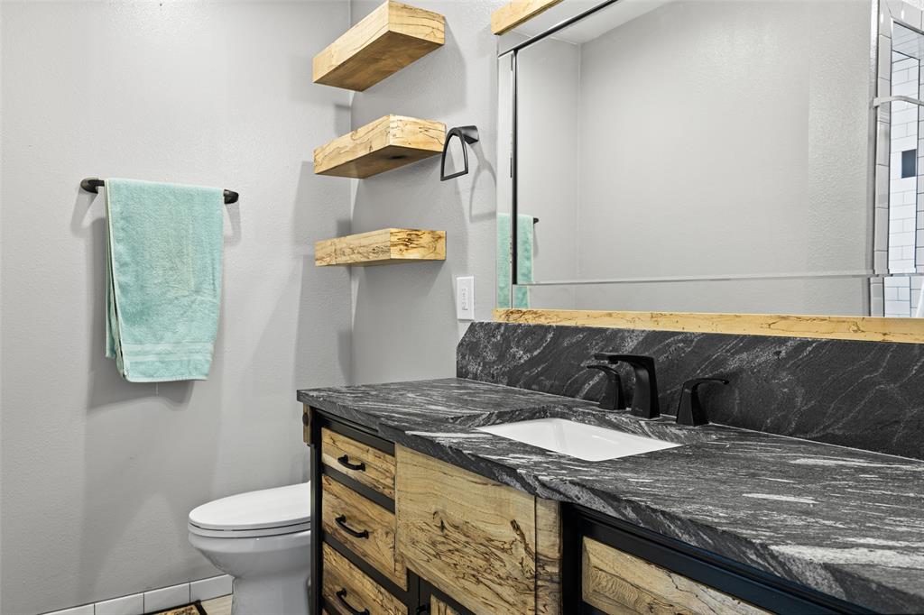 5066 Bob O Link Road Gilmer, TX 75645 - Photo 19 of 30 a bathroom with a granite countertop sink and a toilet