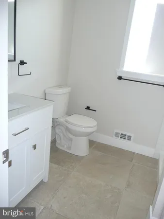 a white toilet sitting next to a bathroom sink