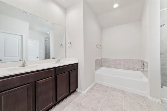 a bathroom with a tub a sink and mirror