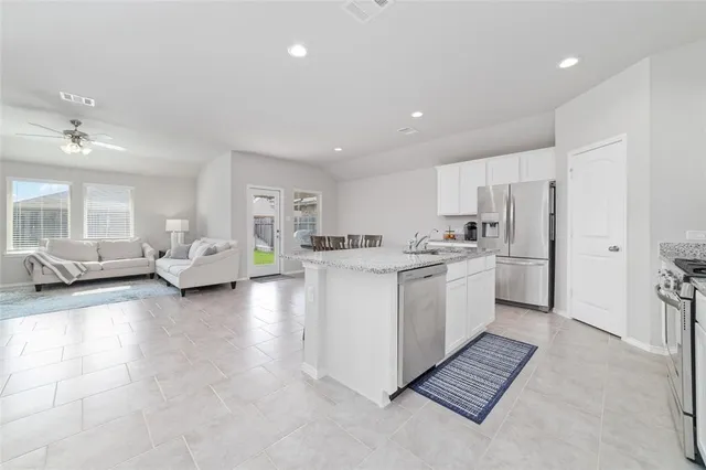 a kitchen with white cabinets and stainless steel appliances