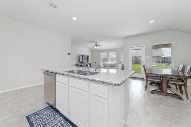 a kitchen with granite countertop a sink and cabinets