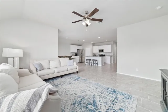 a living room with furniture and kitchen view
