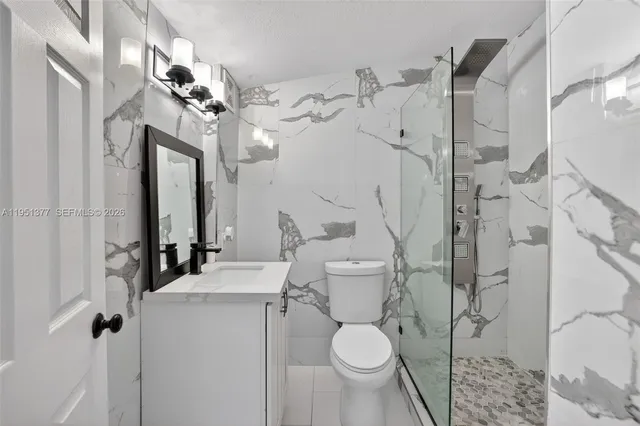 a bathroom with a granite countertop sink toilet and shower