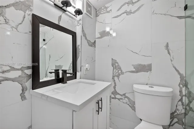 a bathroom with a sink a toilet and a mirror