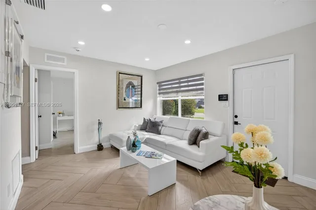 a living room with furniture and wooden floor
