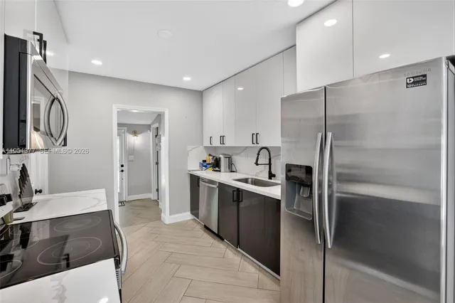 a large kitchen with stainless steel appliances a refrigerator and a sink