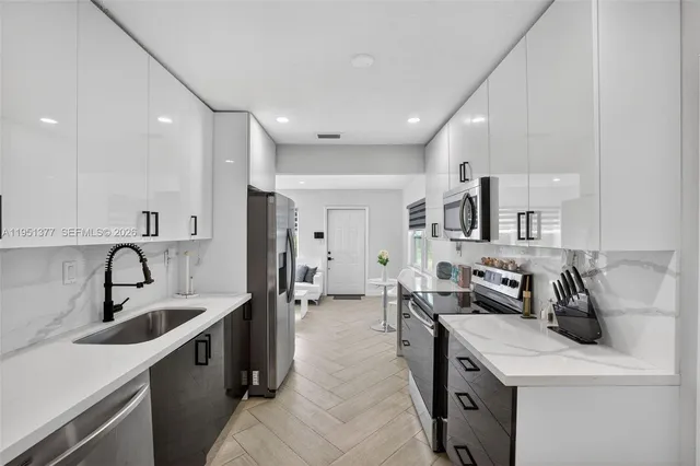 a kitchen with sink refrigerator and stove