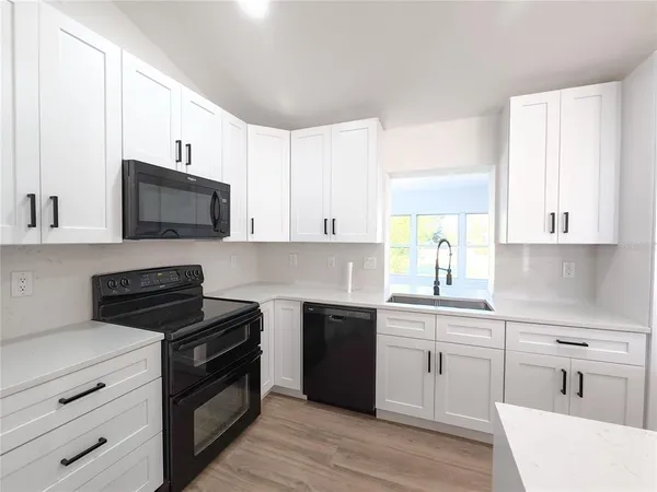 a kitchen with a sink stove and microwave
