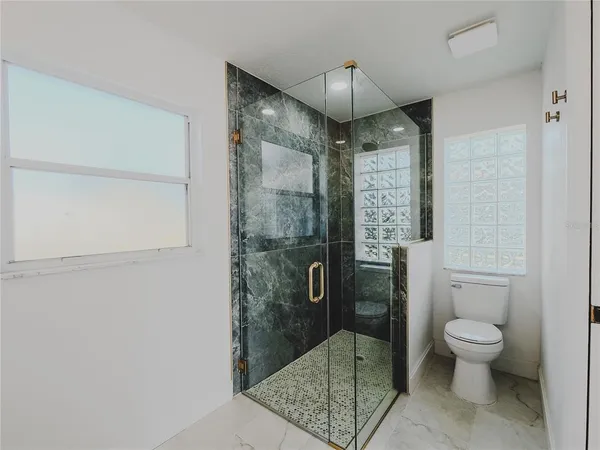 a bathroom with a glass shower door and a toilet