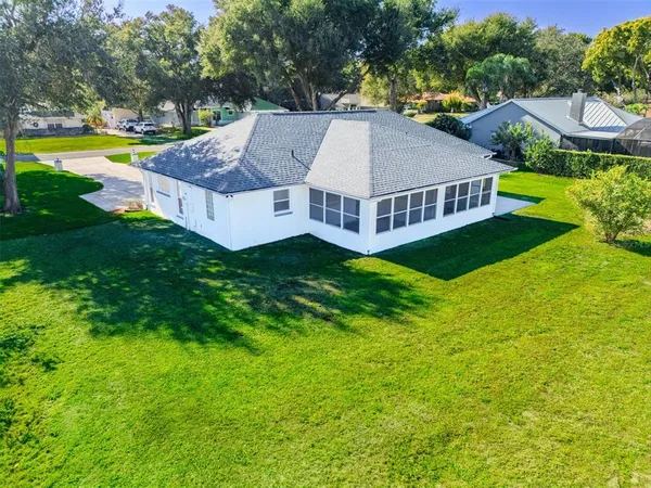 a view of a house with a big yard and large trees