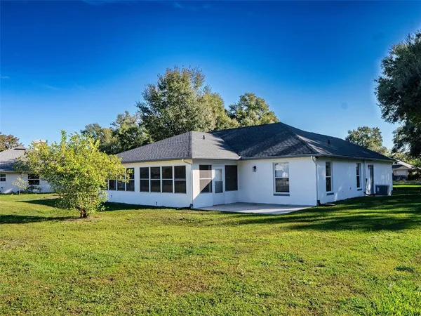a view of a house with big yard and large trees