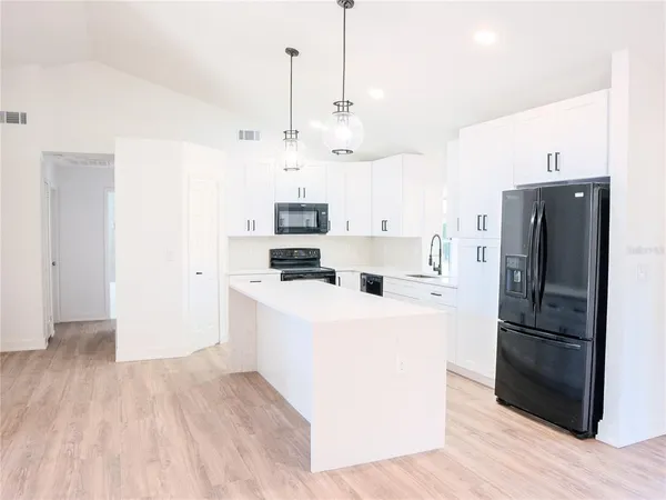 a view of a kitchen with refrigerator and microwave