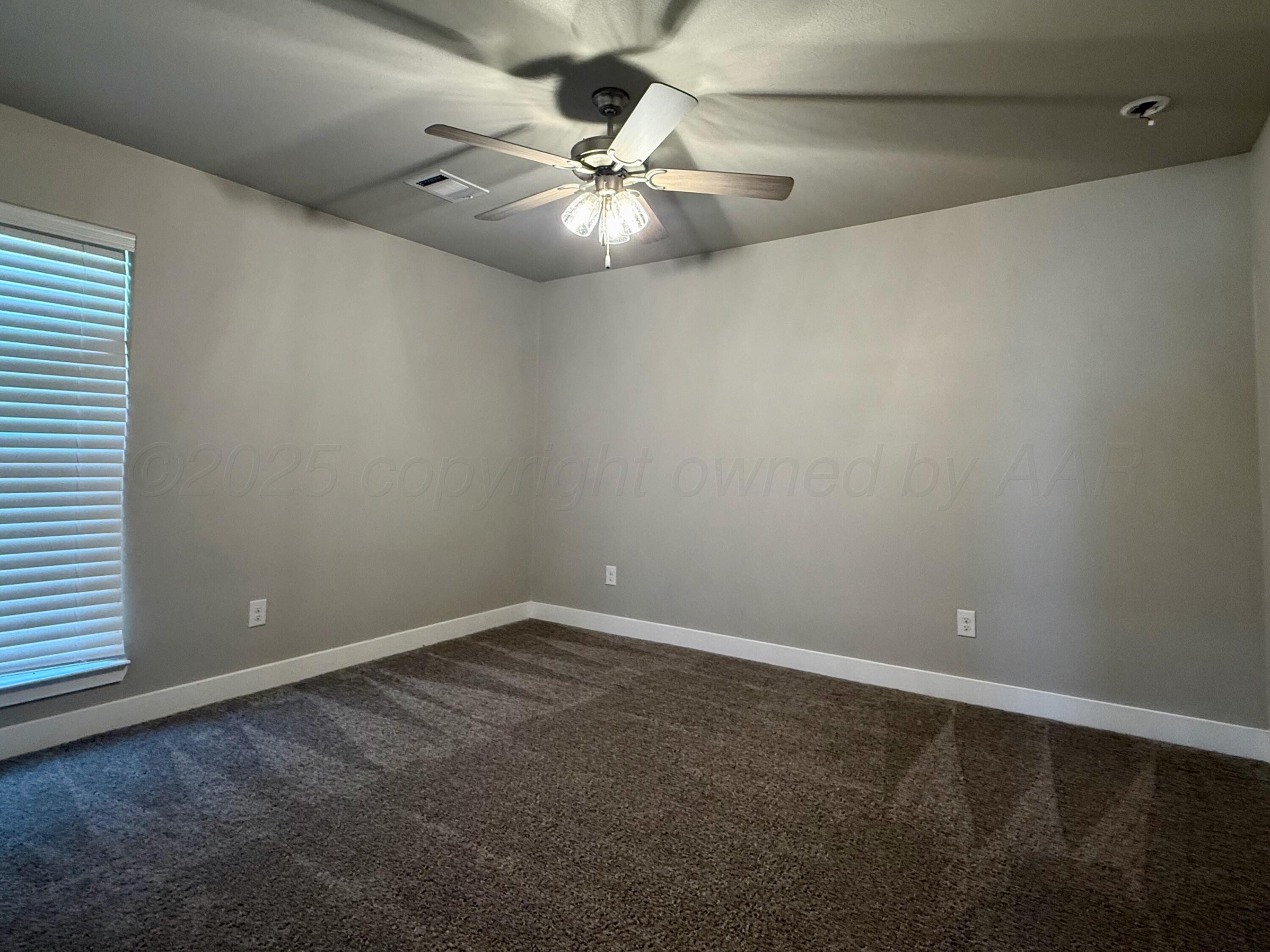 7013 Mercury Trail Amarillo, TX 79118 - Photo 13 of 23 an empty room with a chandelier fan and windows
