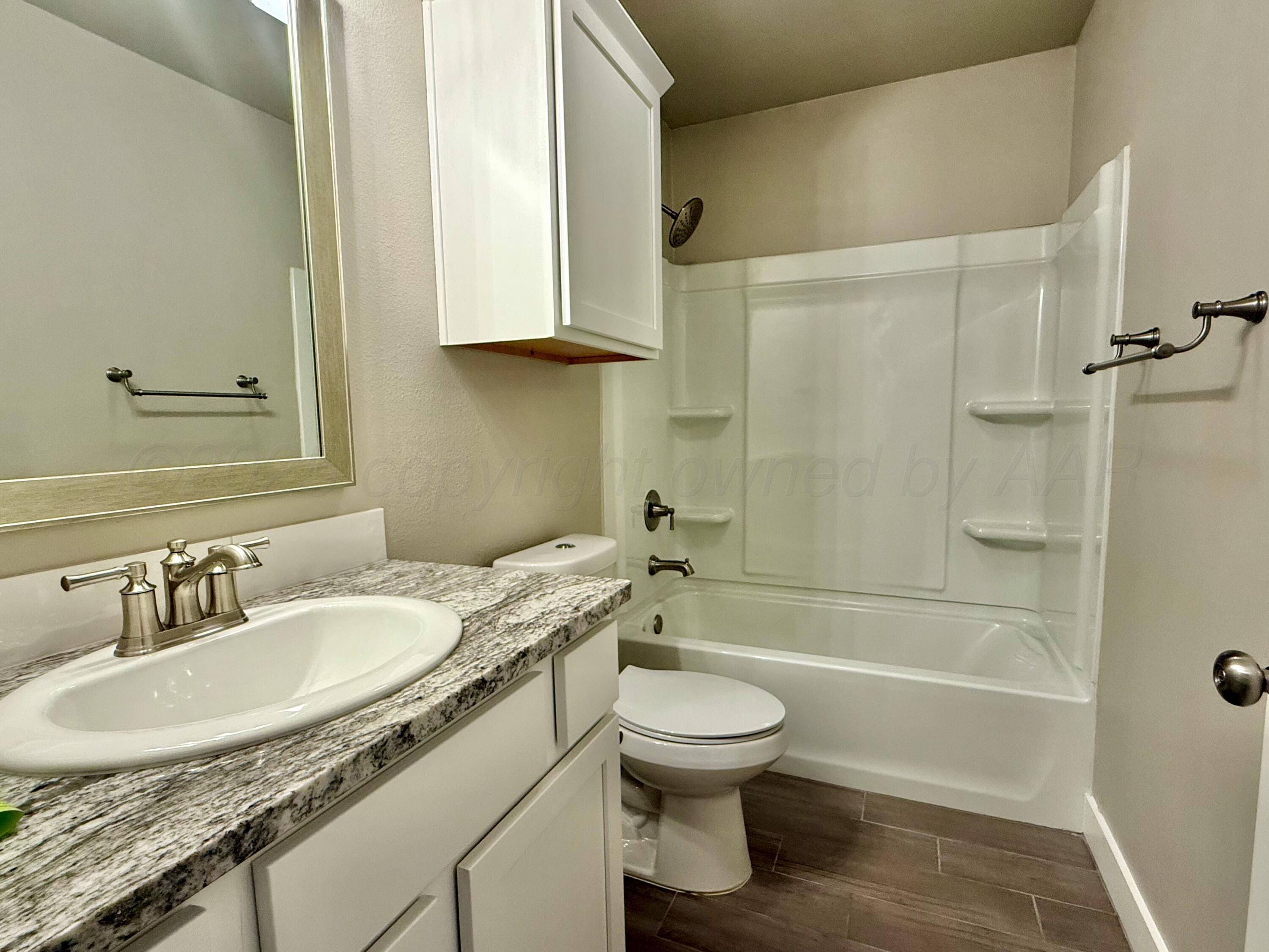 7013 Mercury Trail Amarillo, TX 79118 - Photo 15 of 23 a bathroom with a granite countertop sink toilet and shower