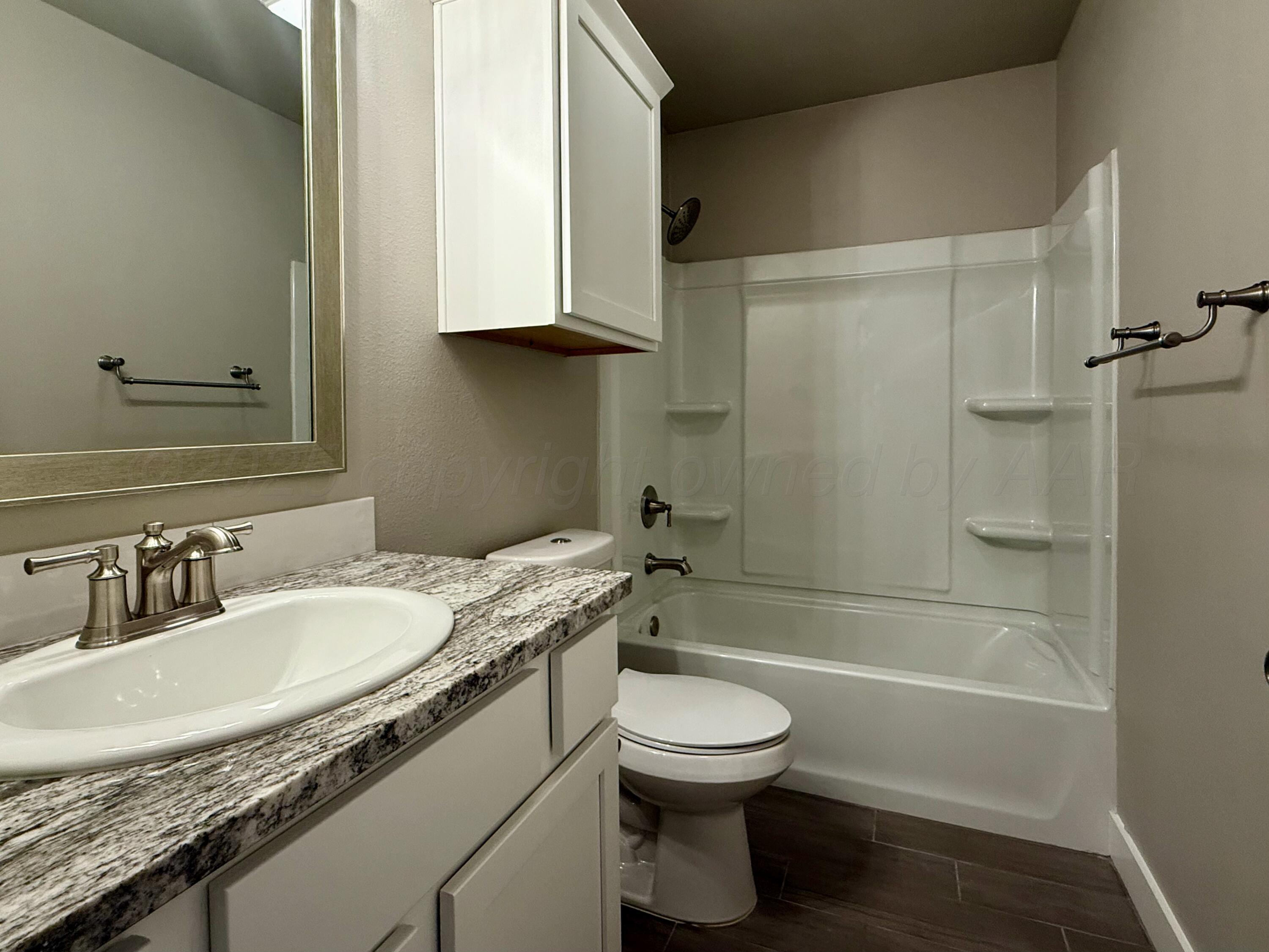 7013 Mercury Trail Amarillo, TX 79118 - Photo 16 of 23 a bathroom with a granite countertop sink a toilet and bathtub