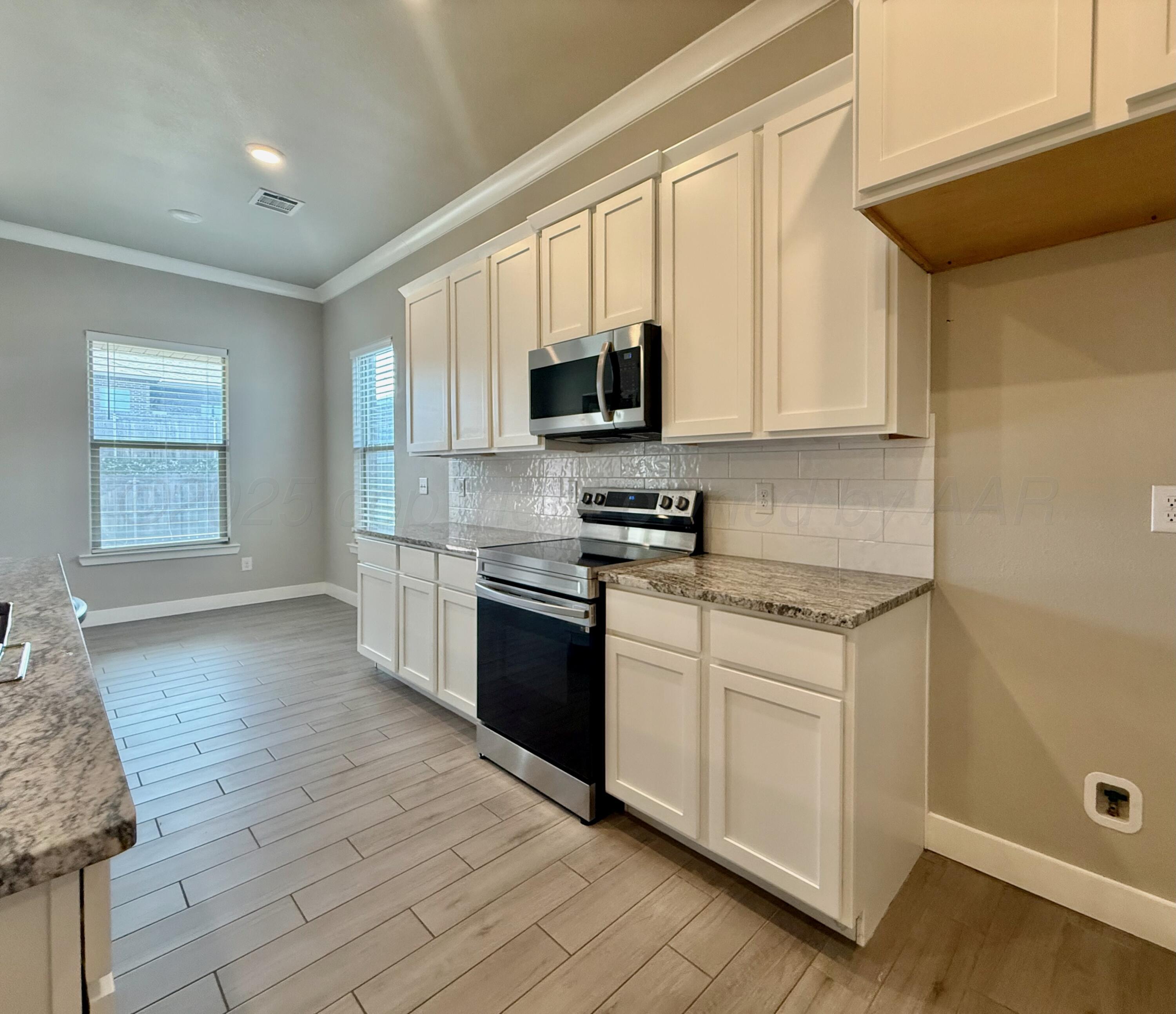 7013 Mercury Trail Amarillo, TX 79118 - Photo 7 of 23 a kitchen with granite countertop a stove top oven a sink dishwasher and a refrigerator with wooden floor