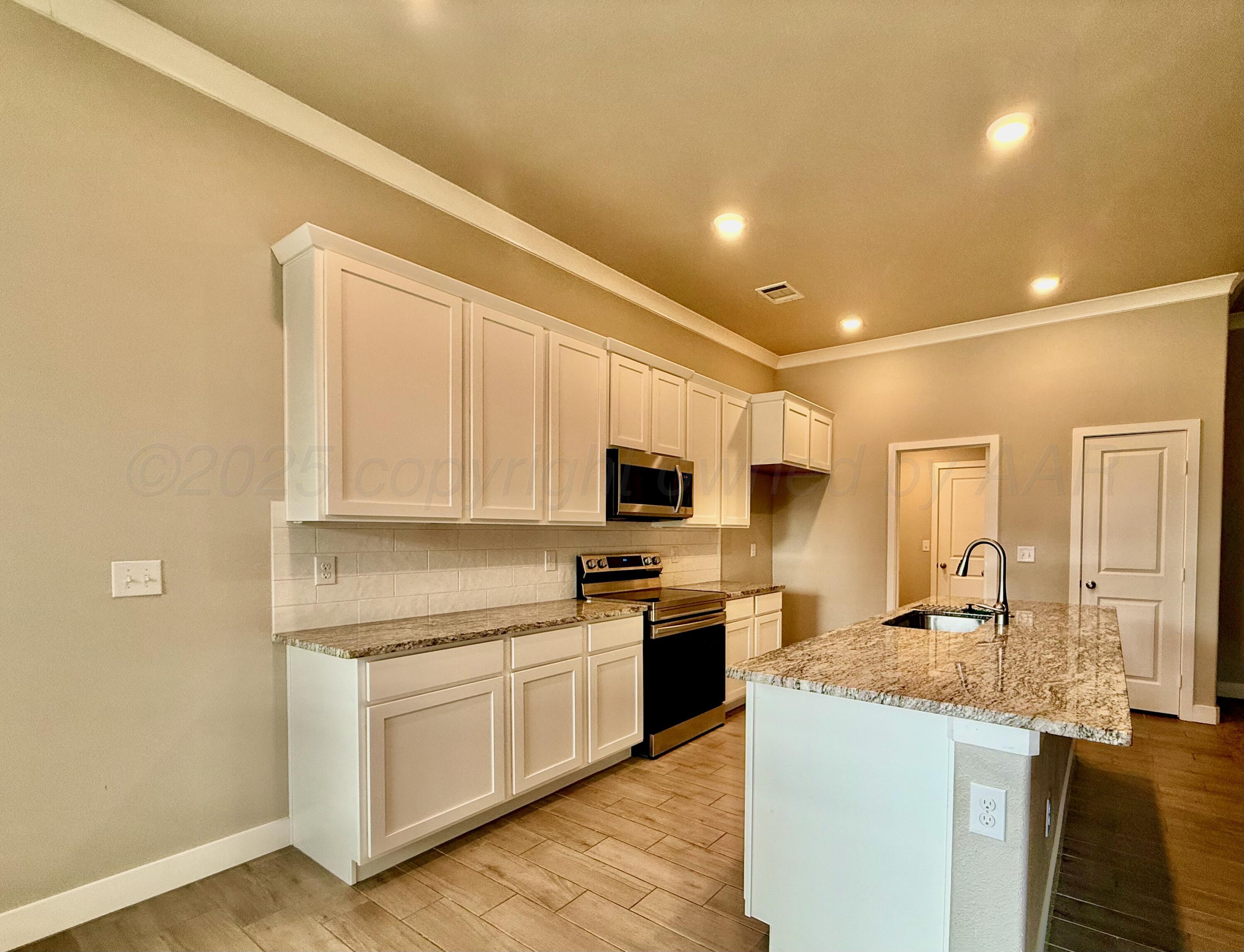 7013 Mercury Trail Amarillo, TX 79118 - Photo 8 of 23 a kitchen with kitchen island granite countertop a stove top oven a sink dishwasher and a refrigerator with wooden floor