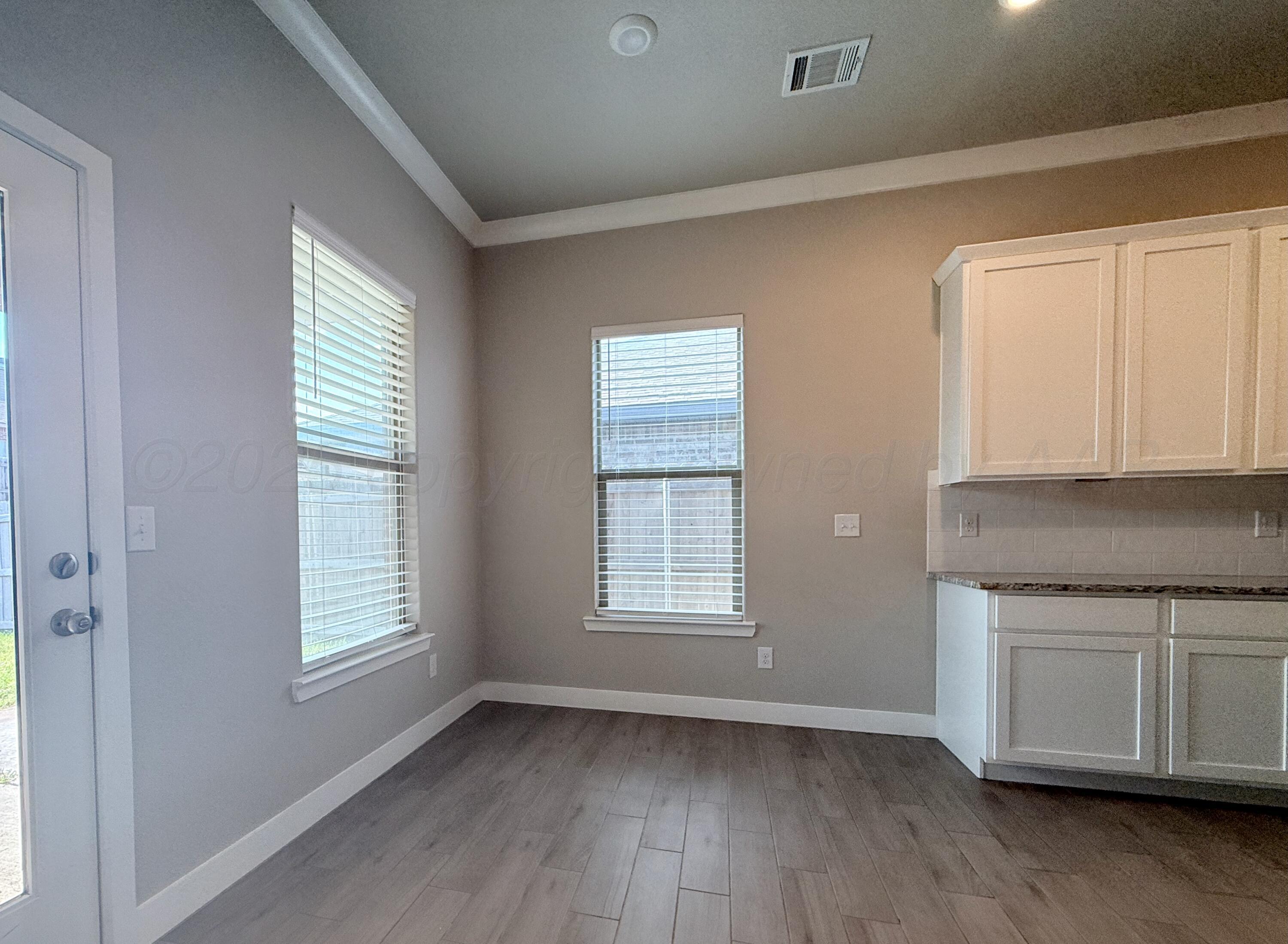 7013 Mercury Trail Amarillo, TX 79118 - Photo 9 of 23 a view of an empty room with a window and wooden floor