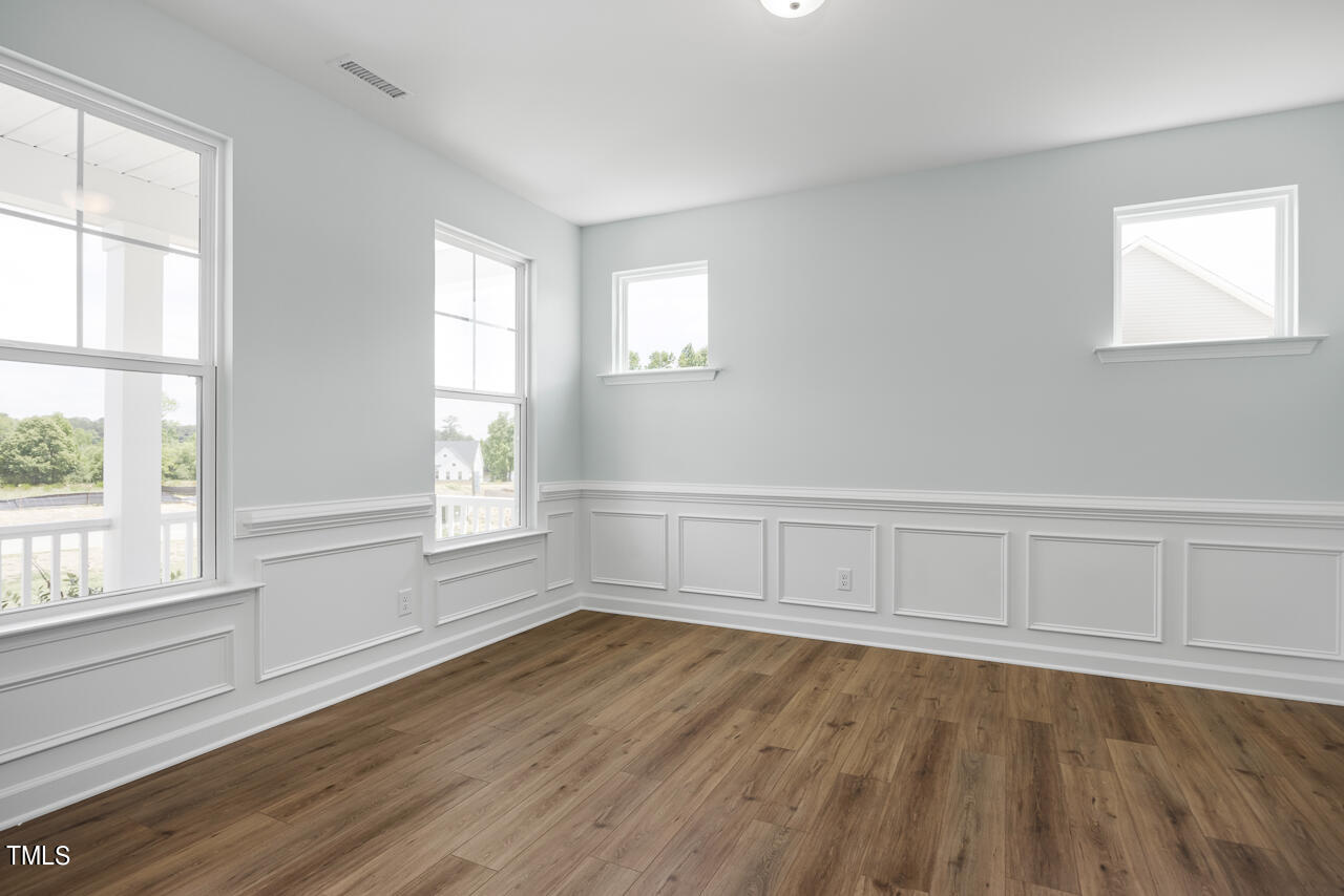63 Golden Leaf Farms Road, Unit 12 Angier, NC 27501 - Photo 4 of 25 an empty room with wooden floor and windows