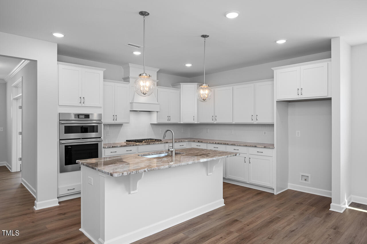 63 Golden Leaf Farms Road, Unit 12 Angier, NC 27501 - Photo 6 of 25 a kitchen with stainless steel appliances granite countertop a sink a stove a refrigerator and white cabinets