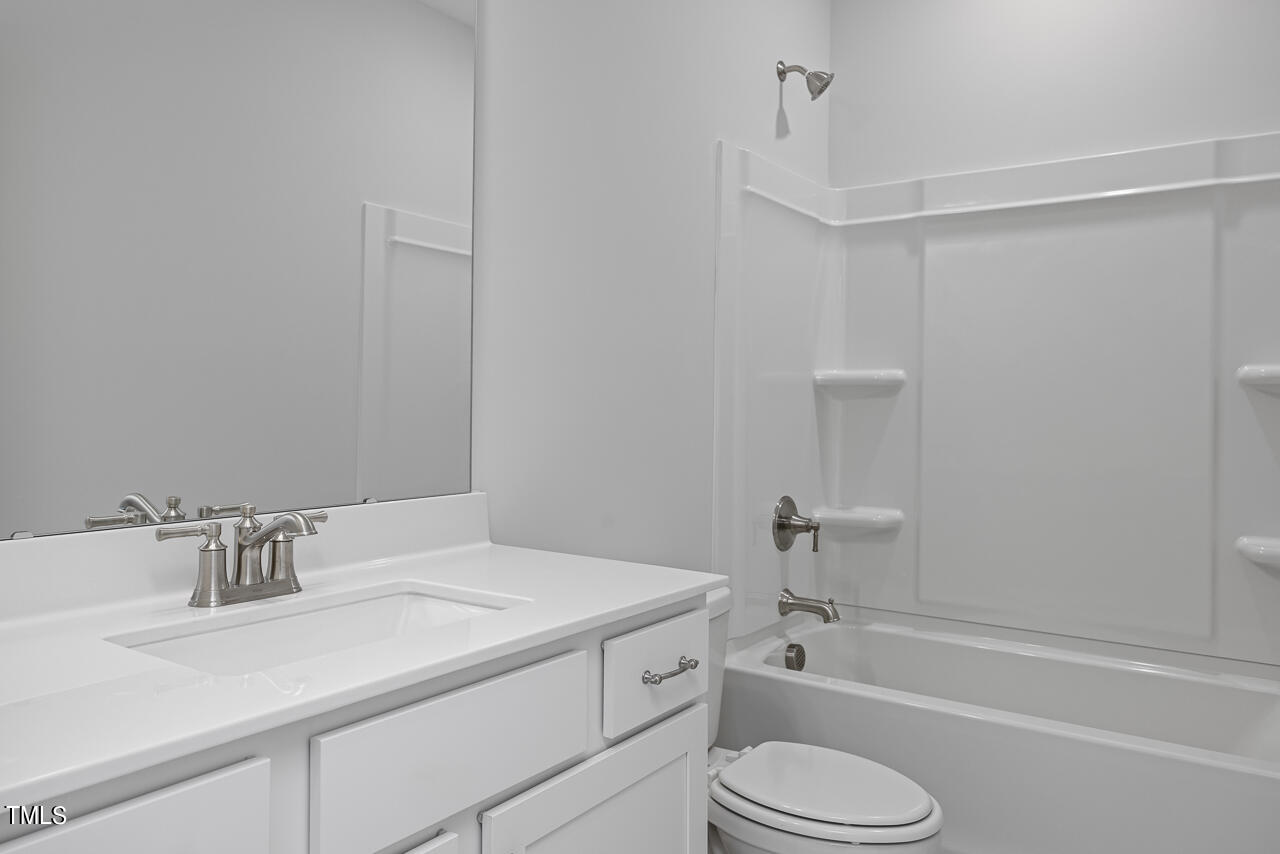 63 Golden Leaf Farms Road, Unit 12 Angier, NC 27501 - Photo 10 of 25 a bathroom with a granite countertop sink toilet and shower